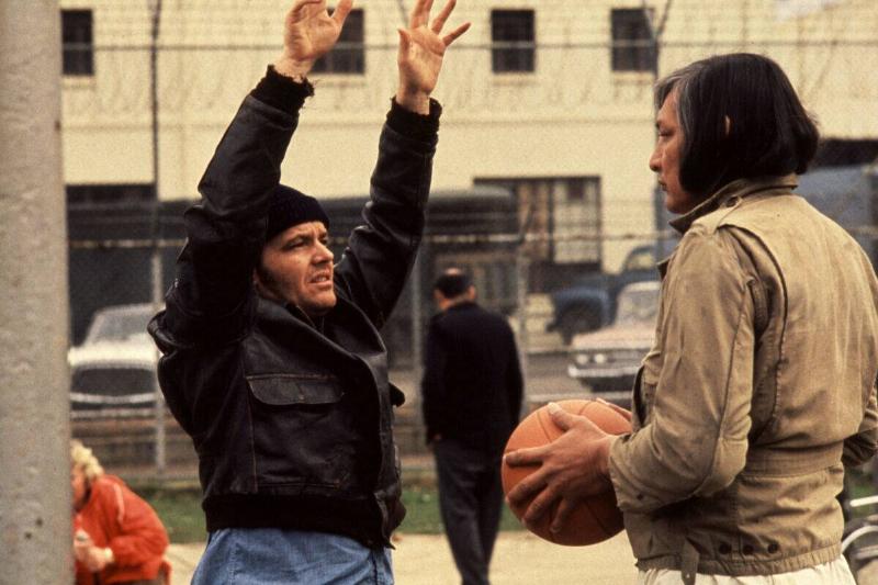 Jack Nicholson putting his hands up as Randle McMurphy while Will Sampson holds basketball as Chief Bromden in One Flew Over the Cuckoo's Nest