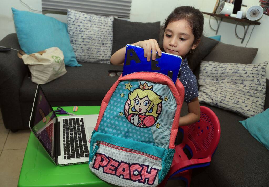 Student taking notebook from backpack