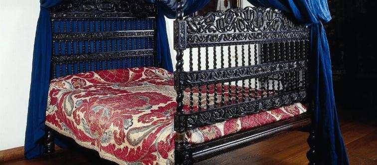 Cot made of ebony with sky made of cotton. Swayed styles and lotus leaf decorations on sills and houses