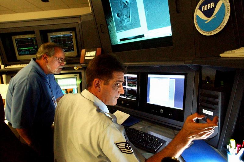 Rick Jacobsen(cq), foreground, and Larry Combs(cq), space weather forecasters at the National Oceanic and Atmospheric Administration, study recent sun flare activity that appears Earth-directed.