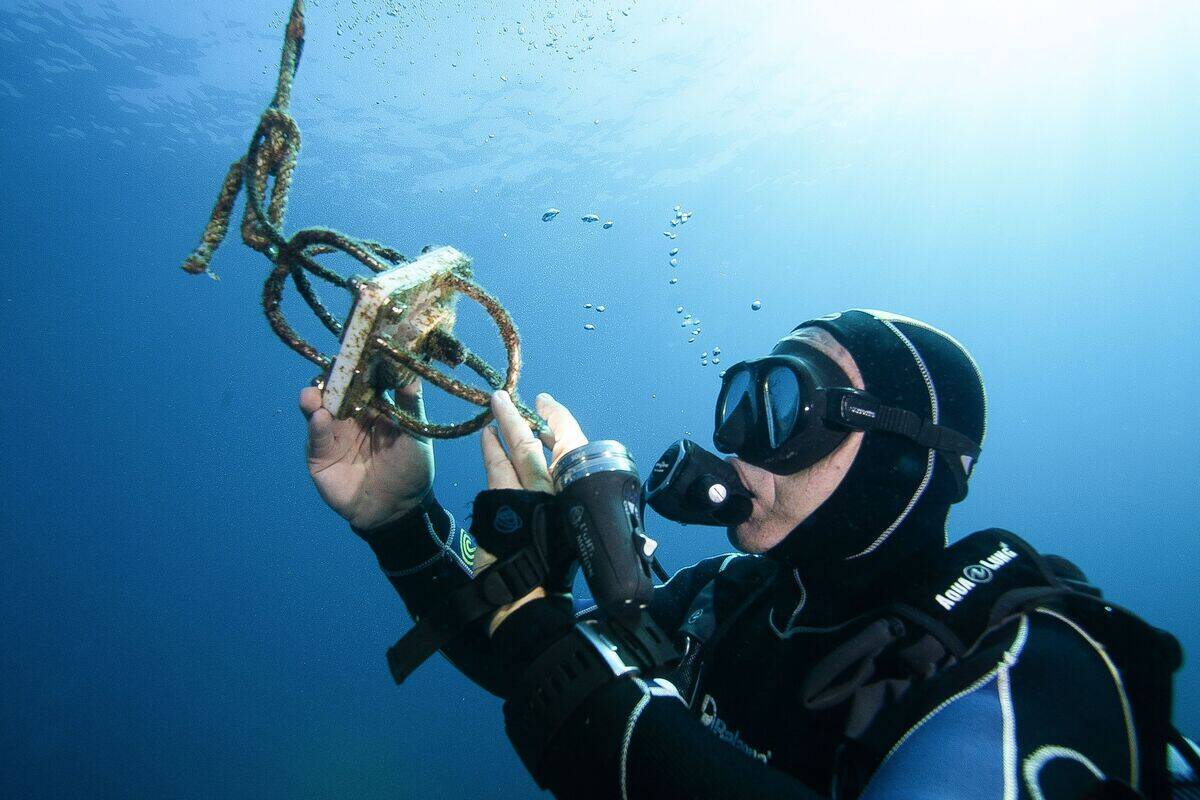 French diver Eric Blin, a water environment and coastline waste-management and biodiversity expert who is taking part in the 'sea@dvanced sound' project, checks a hydrophone off the coast of the Ajaccio, the capital of the French Mediterranean island Corsica on September 11, 2019.