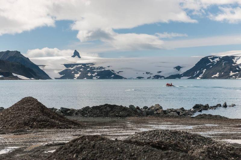 Researchers leaving with the zodiac to collect material with detail of the mooring quay almost submerged by high tide and soil material for earthworks in the foreground, on December 27, 2019 in King George Island, Antarctica.