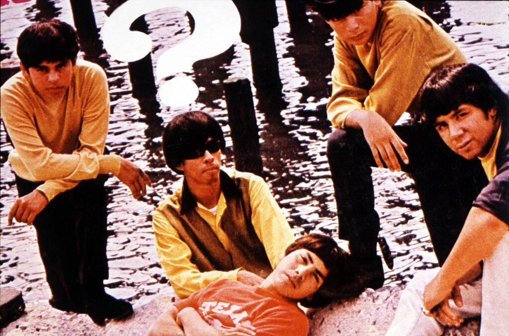 men posing for a photo by the water