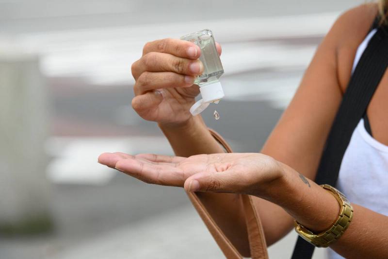 A person uses a hand sanitizer