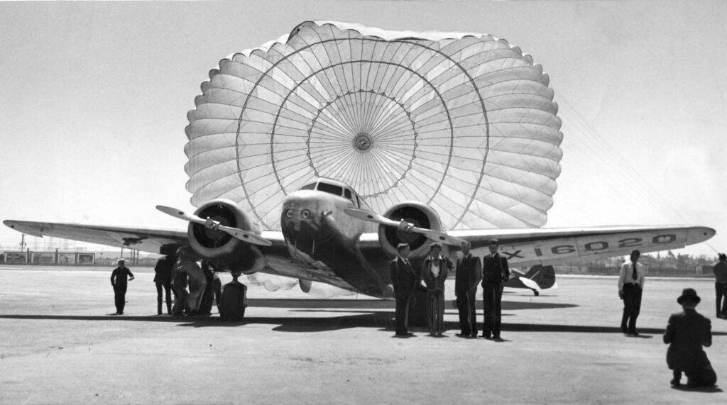 Amelia Earhart and plane at San Francisco Bay Airdrome with plane parachute billowing behind