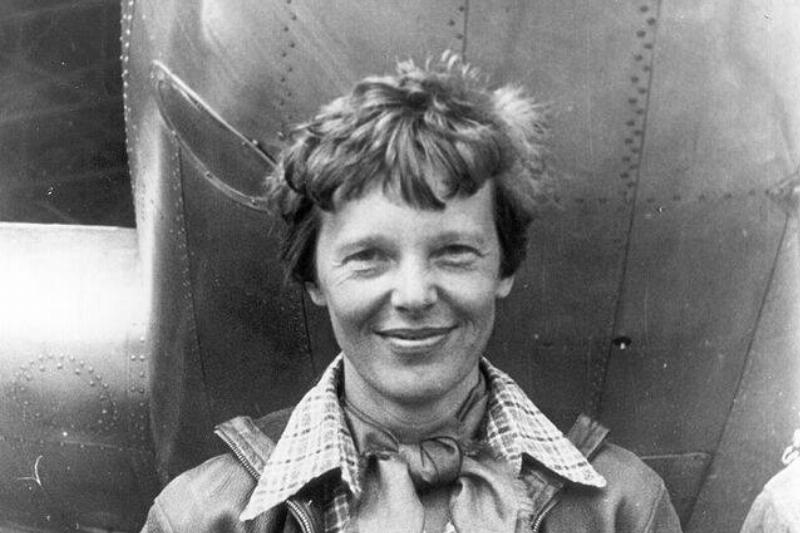Amelia_Earhart_standing_under_nose_of_her_Lockheed_Model_10-E_Electra,_small