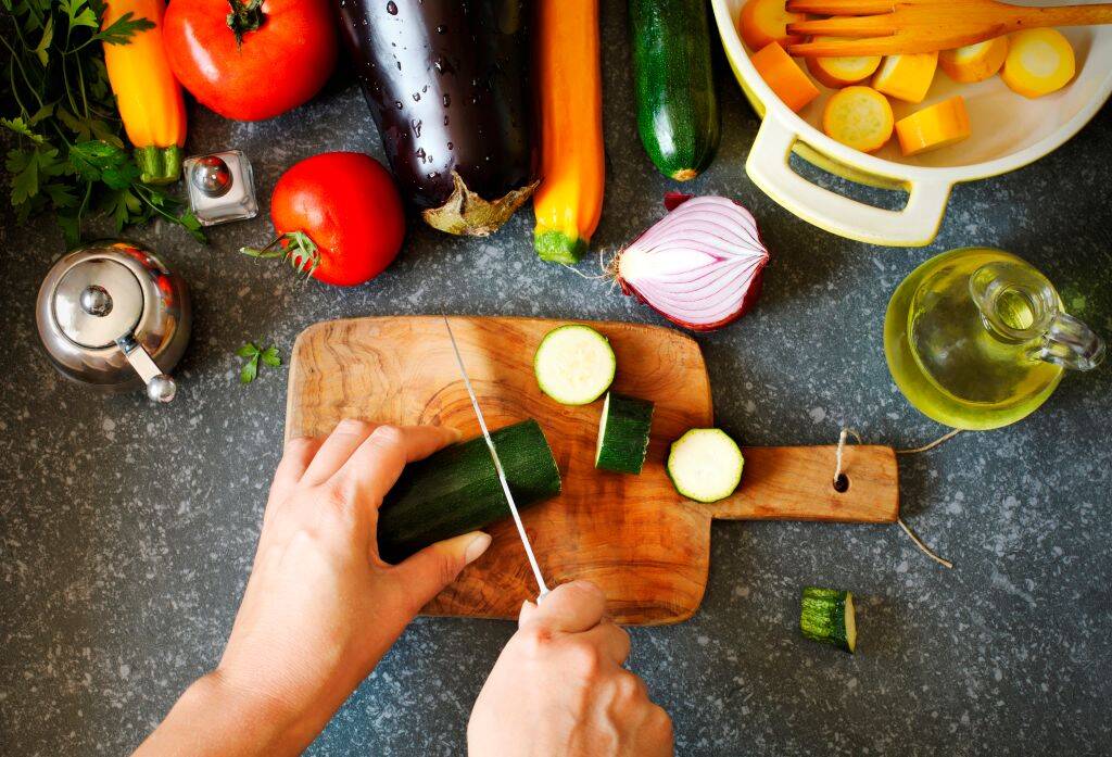 Fresh vegetables and cooking pan on table