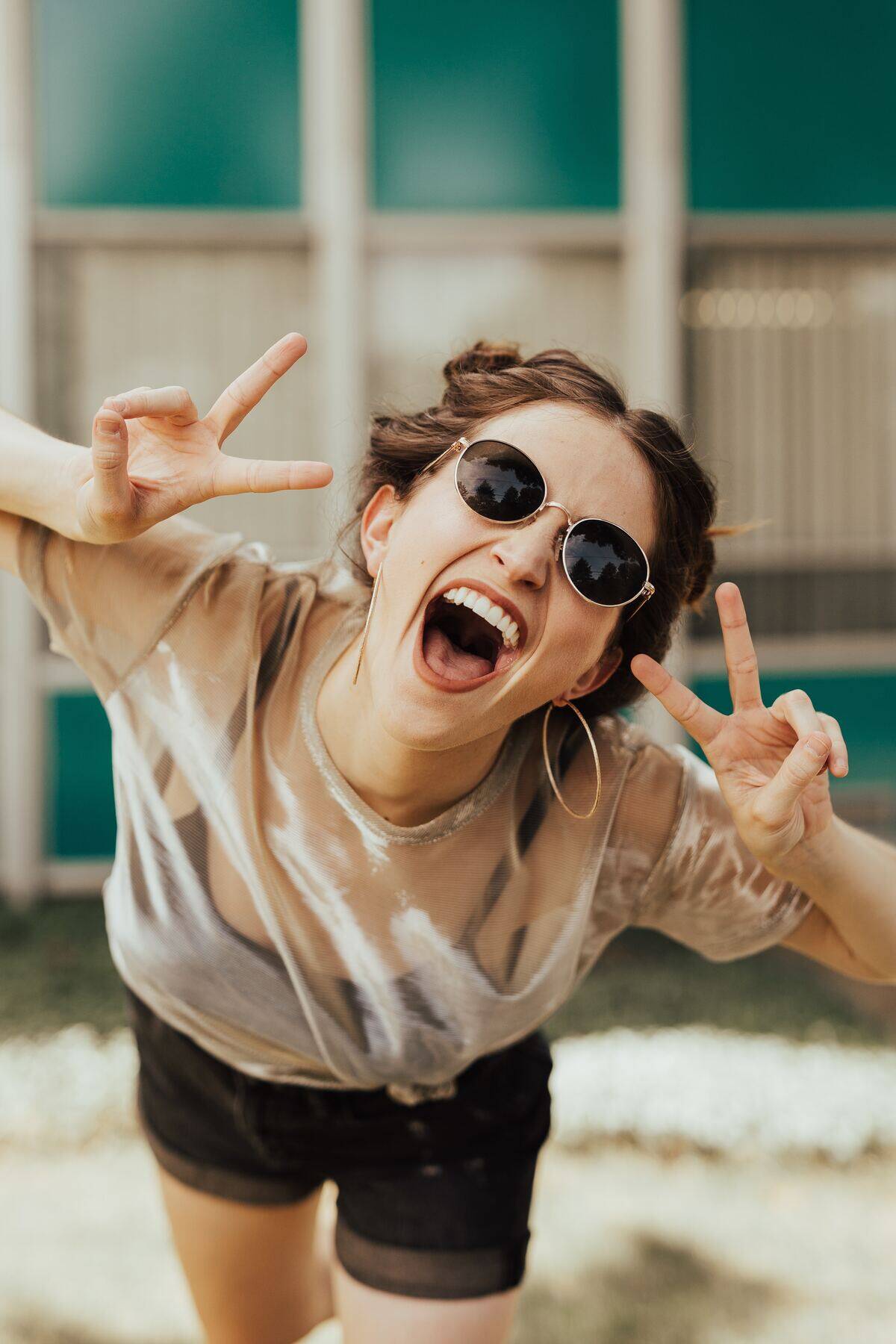 Woman in sunglasses flashing peace signs