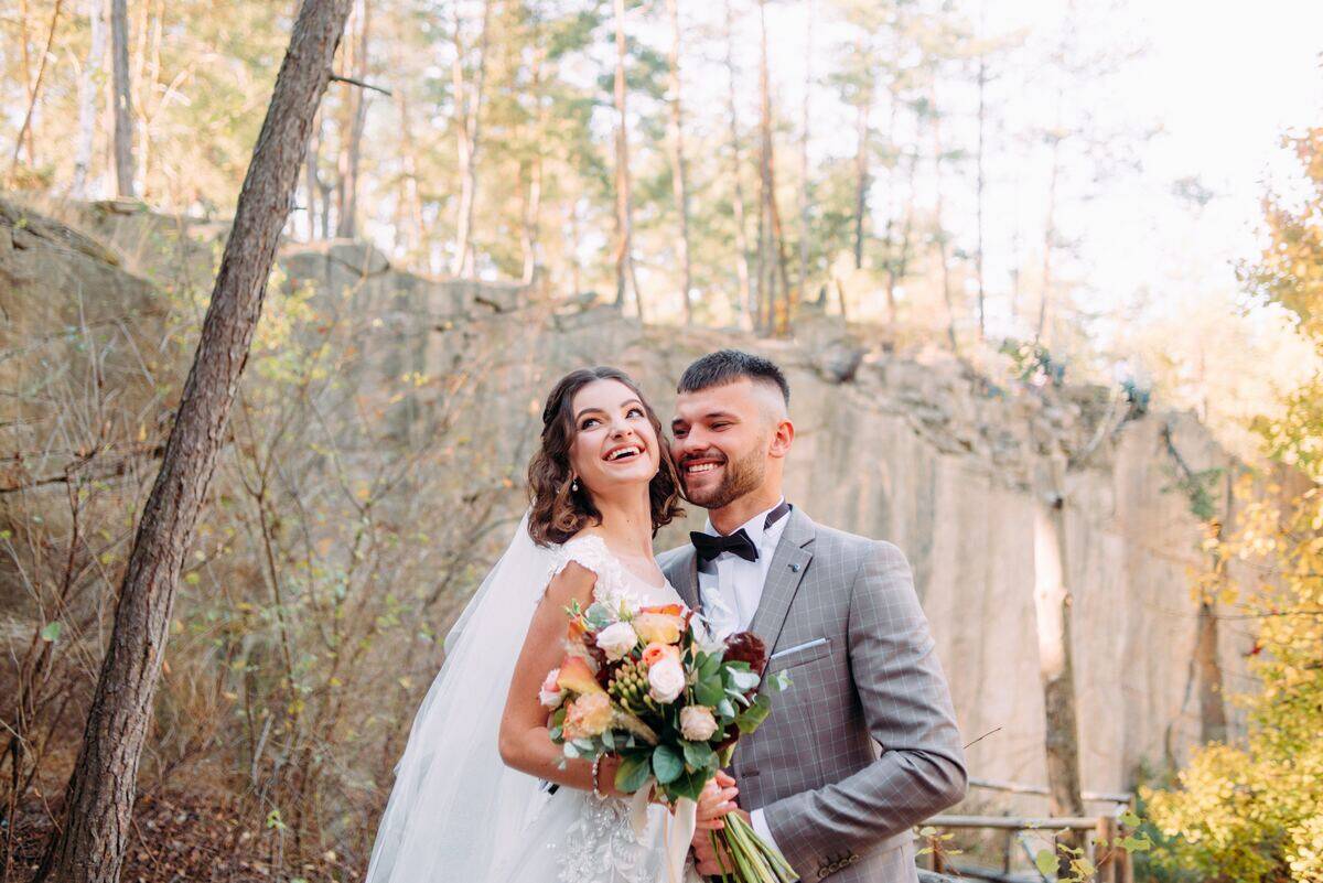 bride and groom smiling in the woods