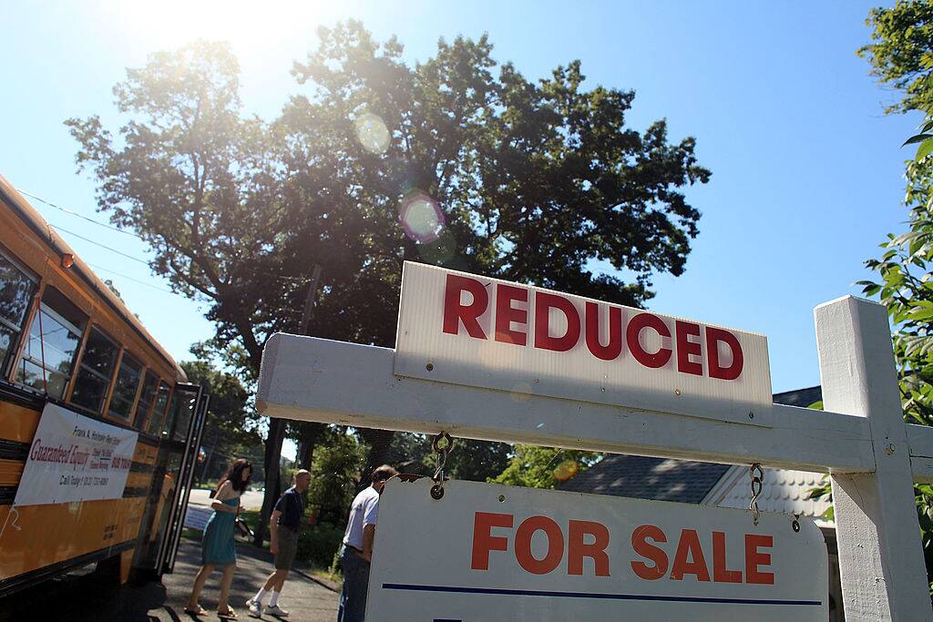 Prospective home buyers exit a bus at a foreclosed home