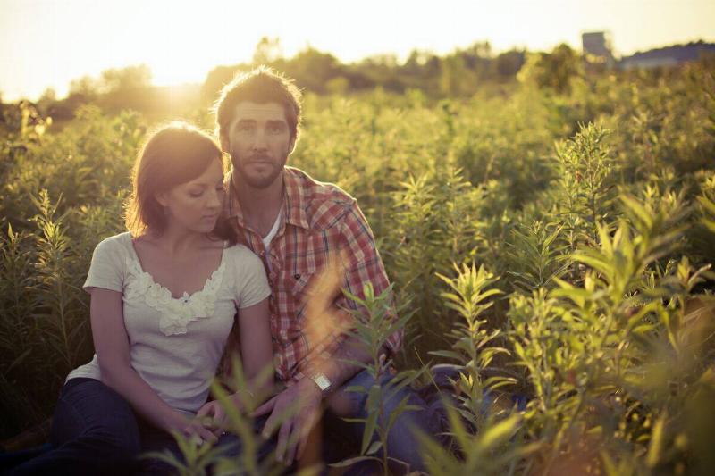couple sits in field