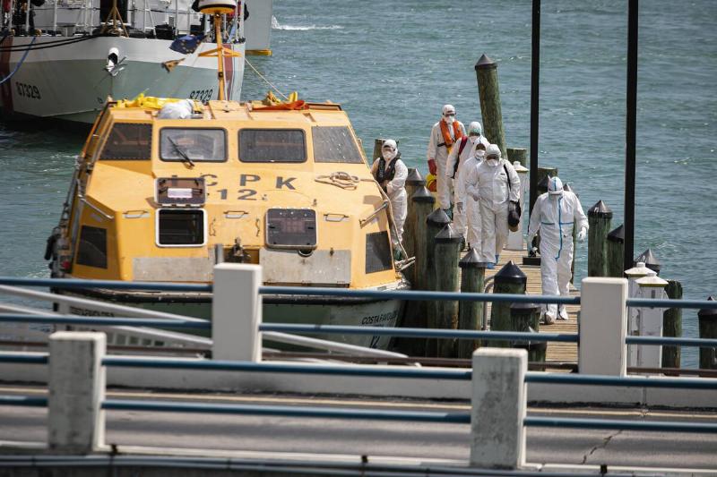 Paramedics dressed in hazmat suits assist the evacuation of cruiseships  crew members with respiratory symptoms associated with coronavirus 
(COVID-19) at the Coast Guardâs Miami Beach station, in Miami, Florida, 
United States on March 26, 2020.