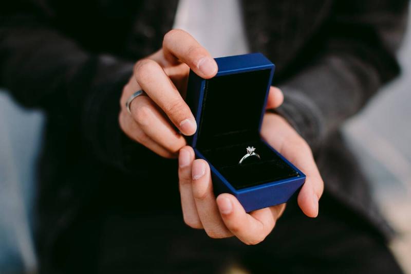 man-holding-engagement-ring-in-box-for-proposal-2021-08-27-17-09-52-utc