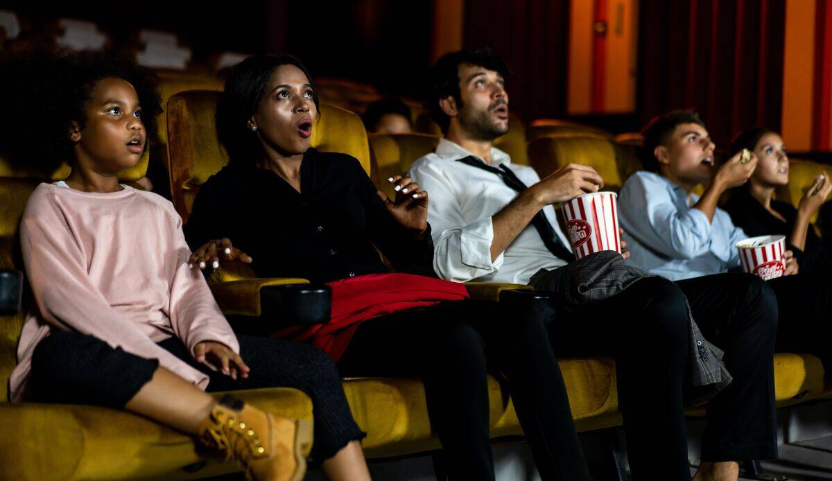 movie theater audience amazed while eating popcorn