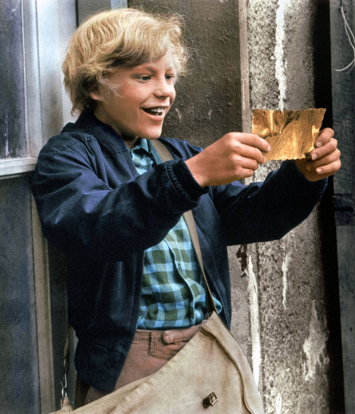 peter ostrum holding a golden ticket in willy wonka and the chocolate factory