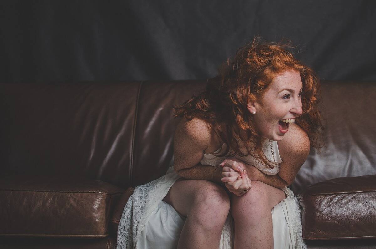 woman in white dress laughing uproariously
