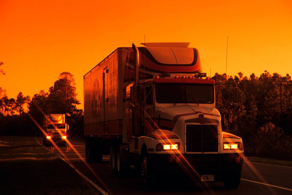 Trucks on the highway at sunset