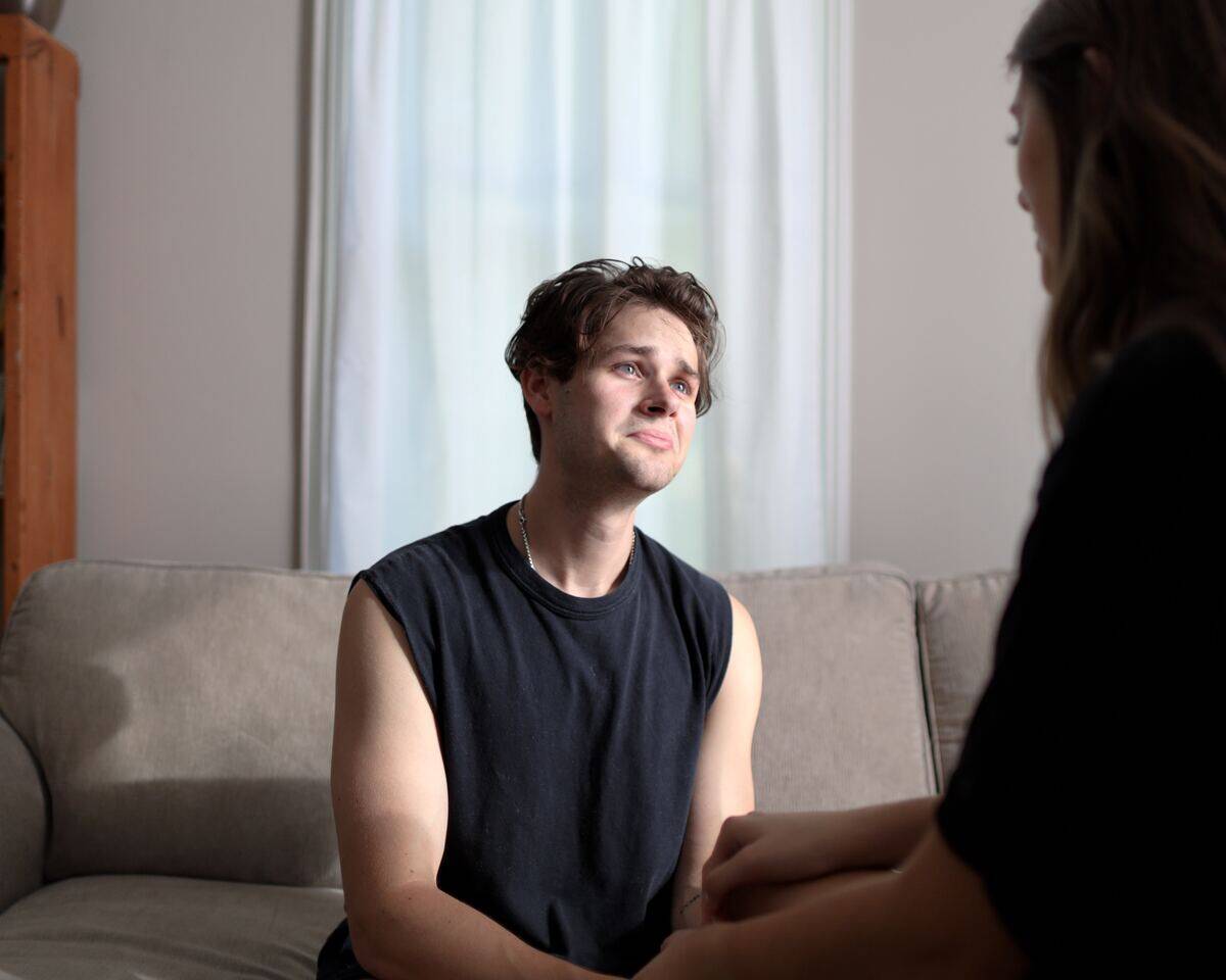 man looking sad while sitting across from woman