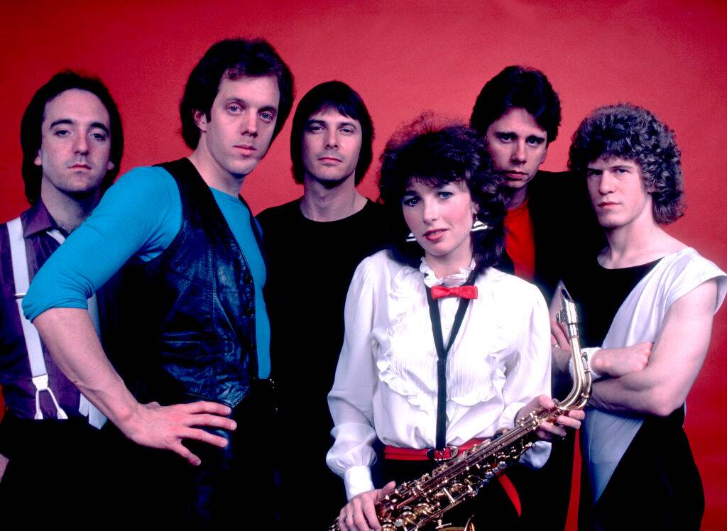 band posing for a photo with red background