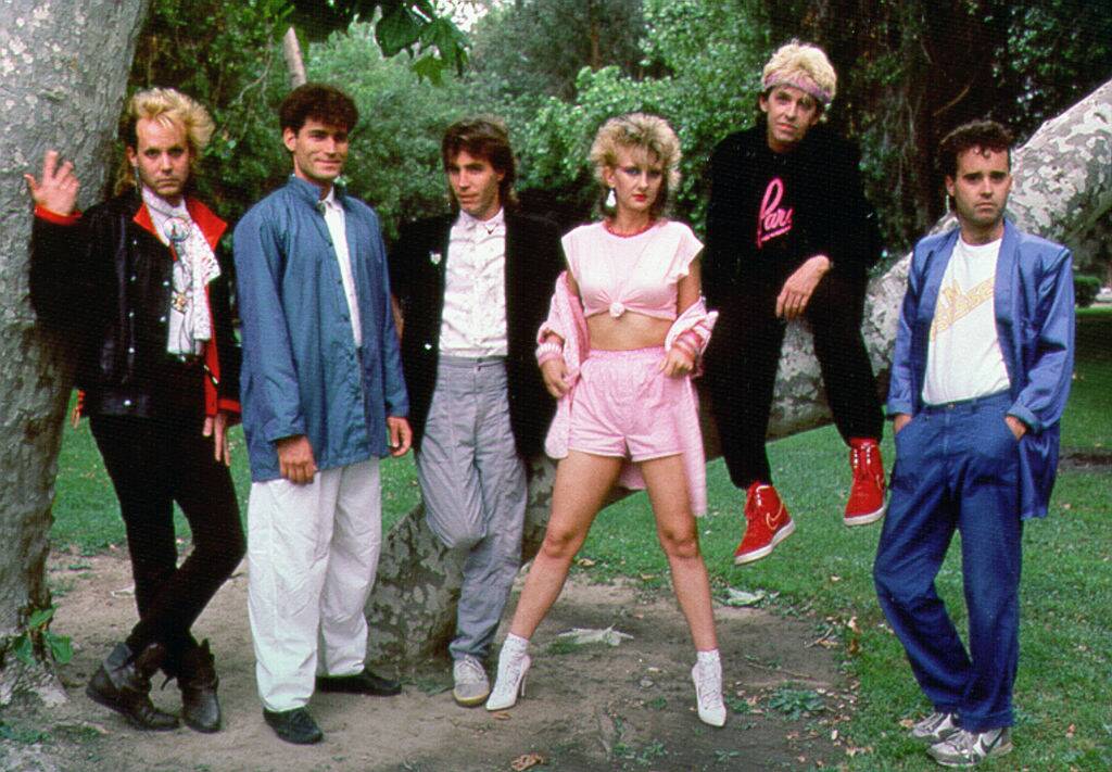 music group posing by a tree