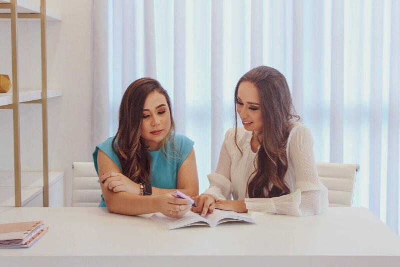women sitting with highlighter near book