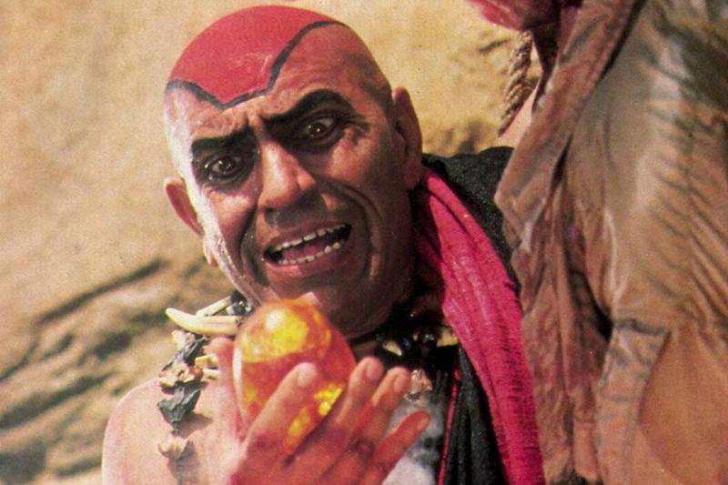 Amrish Puri holding stone while wrestling Harrison Ford in Indiana Jones and the Temple of Doom