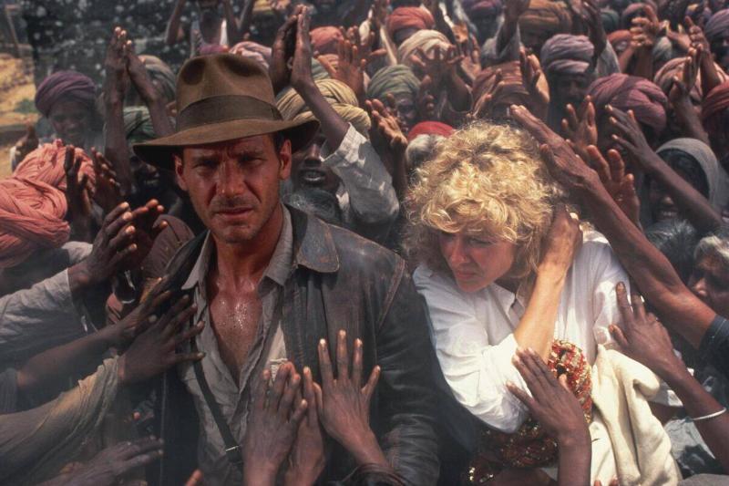 Harrison Ford and Kate Capshaw being grabbed by crowd in Indiana Jones and the Temple of Doom