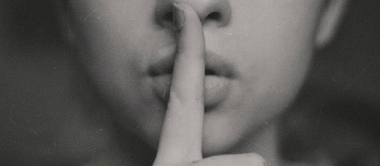 Woman's finger over mouth