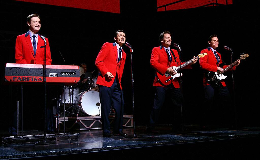 men in red coats performing on stage