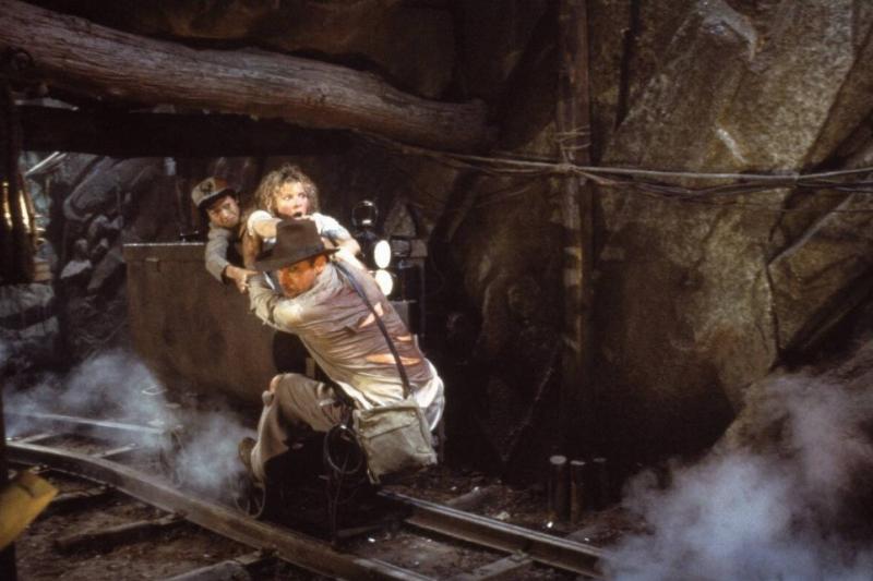 the cast of Indiana Jones and The Temple Of Doom riding mine cart