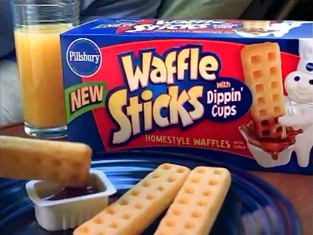 box of pillsbury waffle sticks with some being dipped in syrup