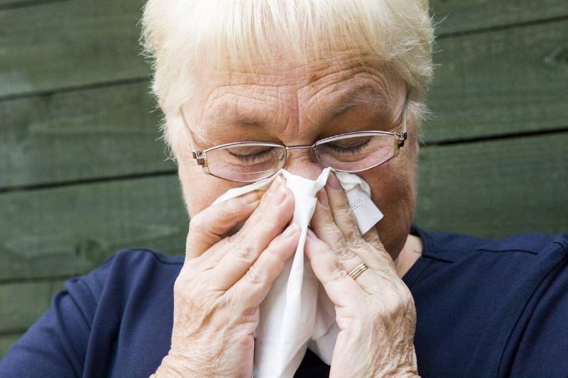 Senior woman blowing nose