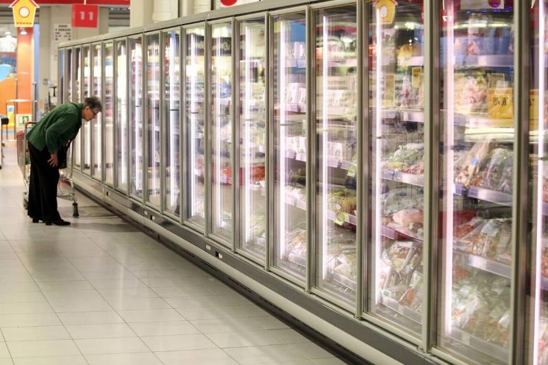 Man looking into a store refrigerator