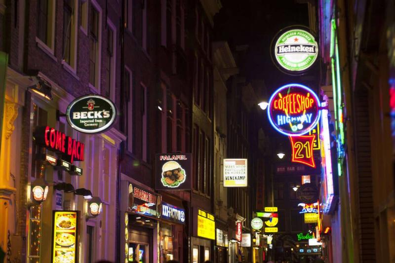 A street scene at night with a coffee shop and colorful neon...