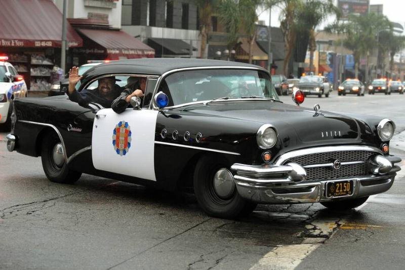 A 1950's eras Buick police car leads a p A 1950's eras Buick police car leads a p