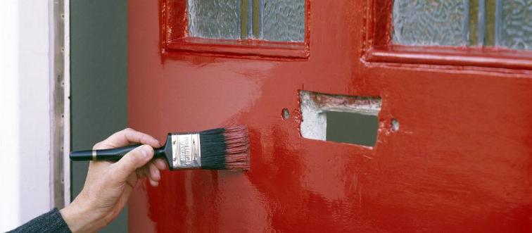 Painting a front door with bright red paint