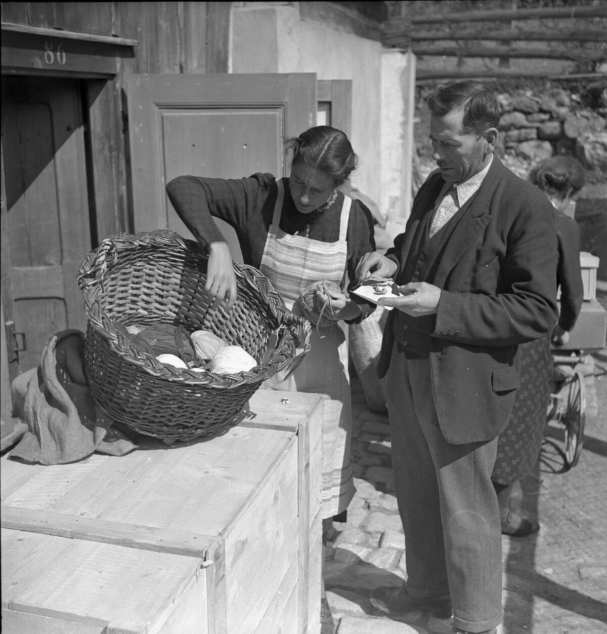 Frau beim Begutachten von Stoffresten für Flickenteppiche, 1940