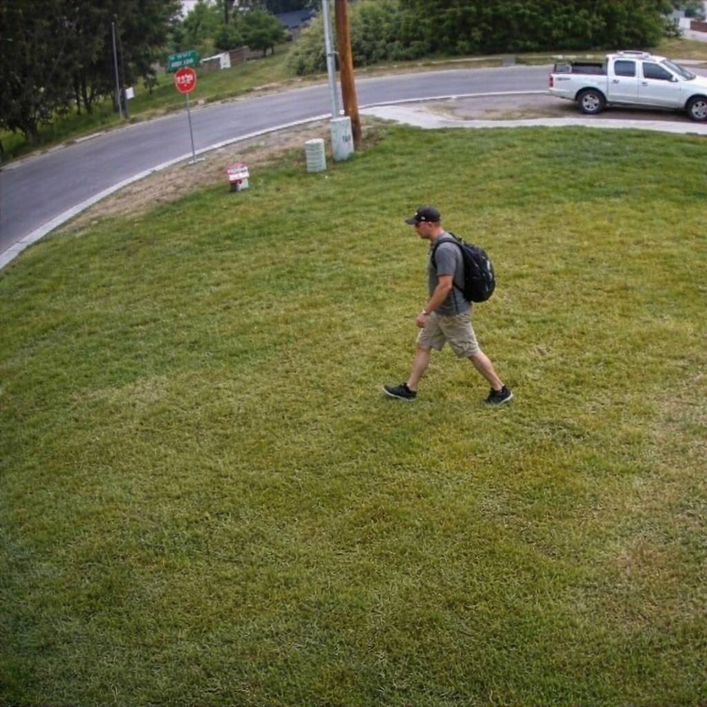 Man walking across someone's front yard