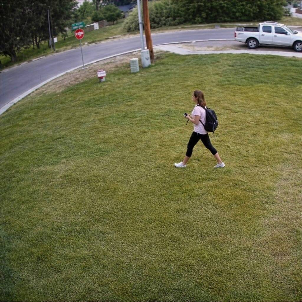 Woman walking across someone's front lawn