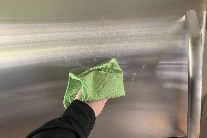 Hand cleaning a fridge.