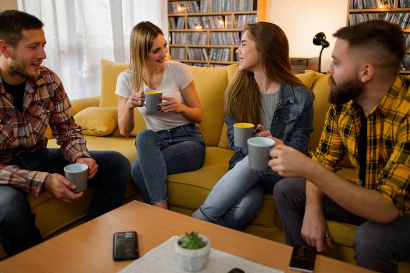 a-group-of-friends-hanging-out-on-a-house-party-an-2025-04-01-13-22-28-utc Frinds sitting together in living room.