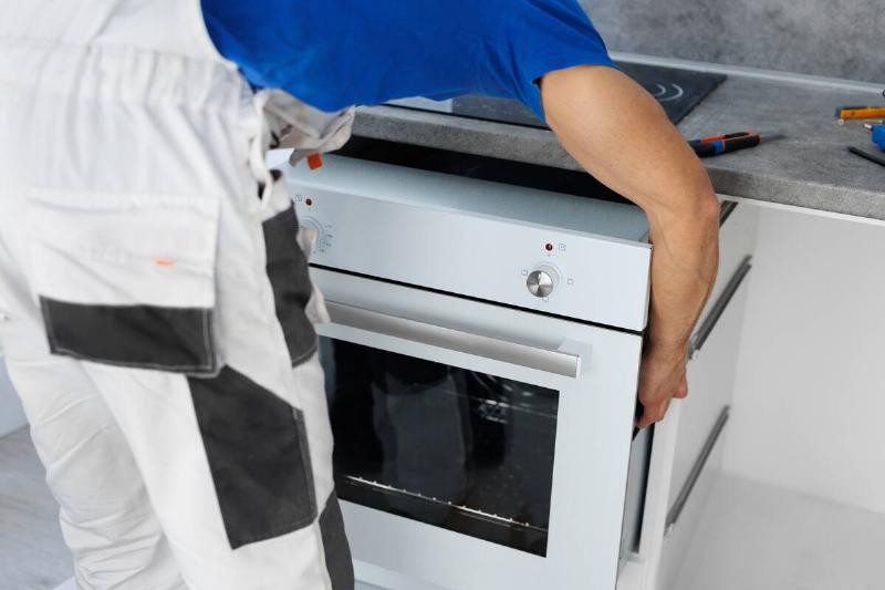a-man-installs-an-oven-after-assembling-the-kitche-2025-01-10-20-40-55-utc A man installs an oven.