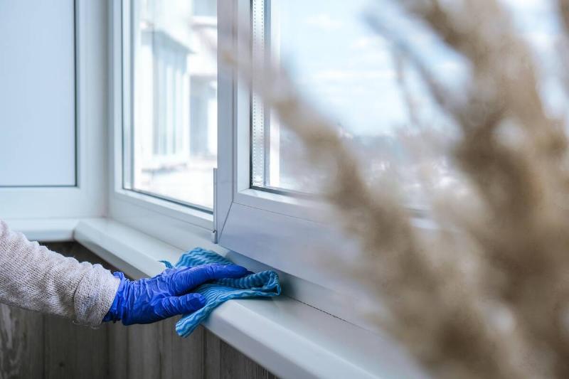 cleaning-the-windowsill-wiping-dust-by-blue-microf-2025-03-10-21-39-07-utc Hand cleaning dust off windowsill.