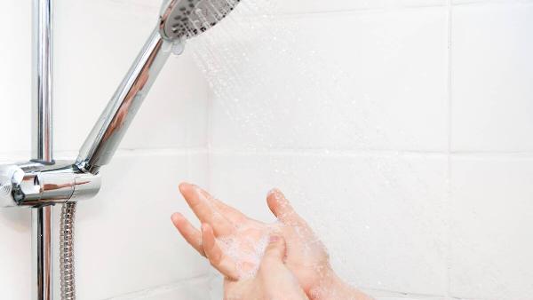 Woman feeling shower water pressure.