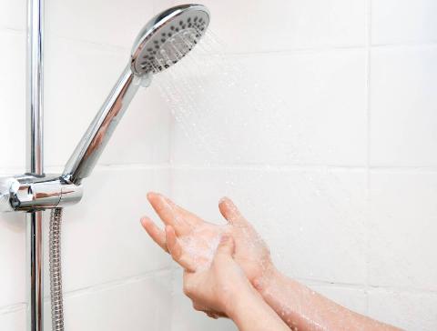 Woman feeling shower water pressure.
