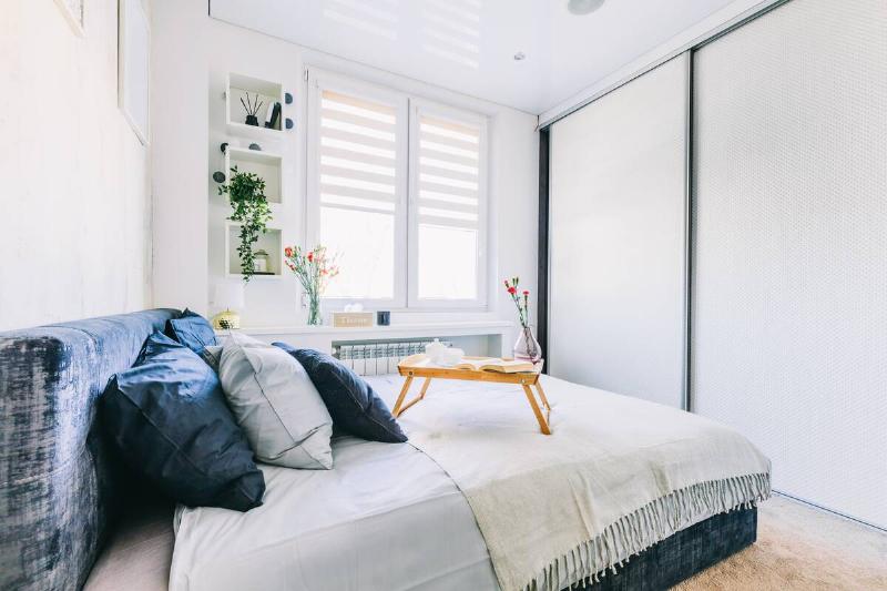 coffee-and-flowers-on-bed-tray-in-elegant-bedroom-2025-03-24-09-33-47-utc Small bedroom with a big window.