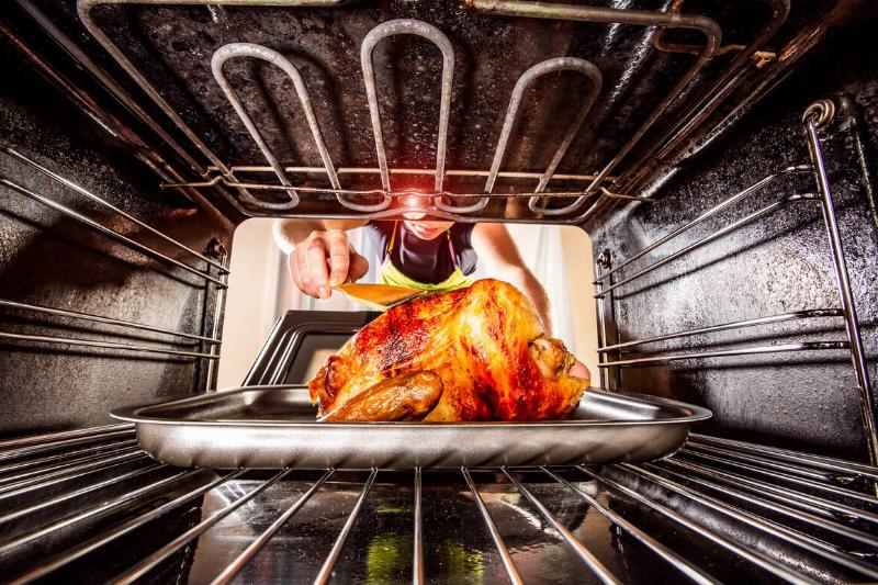 A turkey cooking in an oven.