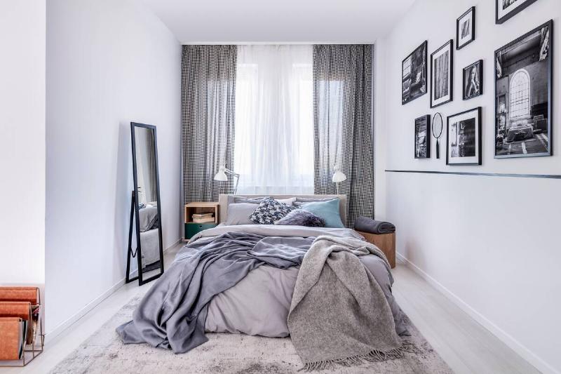 cozy-king-size-bed-with-grey-bedding-and-warm-blan-2025-10-11-12-03-31-utc Tall mirror is a small bedroom.