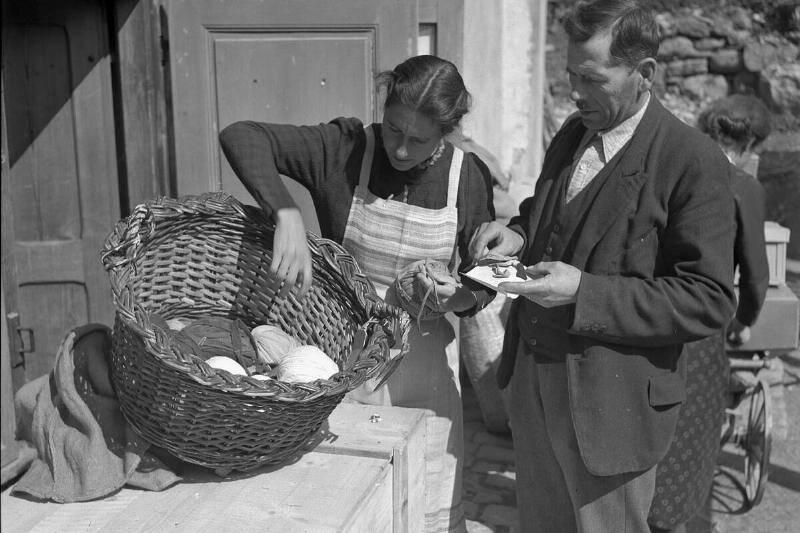 frau-beim-begutachten-von-stoffresten-fur-flickenteppiche-1940-76872