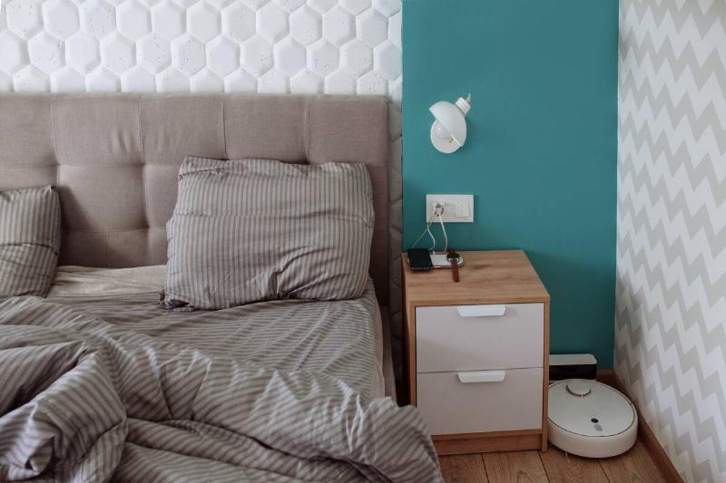 интерьер-бело-серой-уютной-спальни-робота-пылесоса-2025-03-08-15-34-36-utc Приставной столик в спальне, на нем ничего особенного.